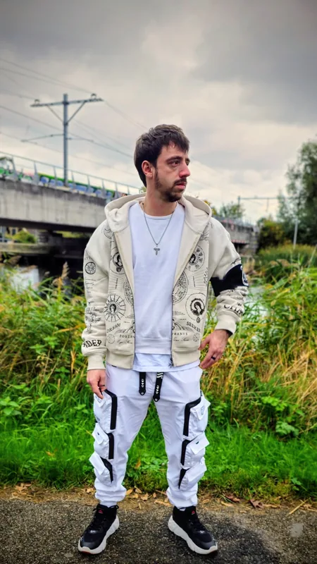 Victor, standing by a bridge on an overcast afternoon.